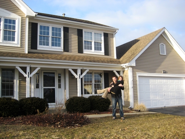 Happy couple in front of house