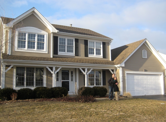 Happy couple in front of home